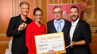 Jörg Pilawa, GKL-Vorstandsvorsitzende Bettina Rothärmel und Moderator Eric Schroth überreichen Hans H. (2. v. r.) einen Scheck über eine Million Euro.