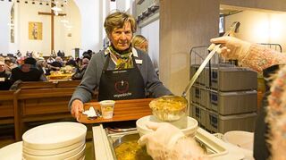 Zu den Aufgaben der ehrenamtlichen Helfer und Helferinnen gehört es auch, Essen und Getränke auszuteilen und an Tischen zu bedienen.