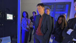 Minister Lauterbach vor einem Mikroskop im Bildgebungs-Center des EMBL, das auch ein Kühlschrank ist: Hier werden Zellen gefroren untersucht.