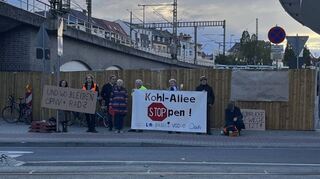 Außerhalb der Baustelle demonstrieren bei der Grundsteinverlegung für den Neubau der Hochstraße Süd Menschen für eine Stärkung von Radverkehr und ÖPNV.