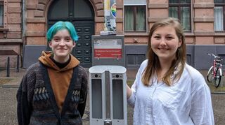 Emma Hoffmann (l.) und Jasmin Hildebrandt vom Jugendprojekt #keepitclean präsentieren einen der neuen Abstimm-Aschenbecher im Jungbusch.