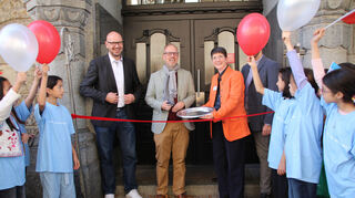 Offizieller Abschluss der Sanierung mit Zerschneiden des Bands (v.l.): Bernd Schmid-Ruhe (Fachbereich Bildung), Bürgermeister Dirk Grunert, Direktorin Manuela Weiss.
