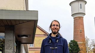 Yannic Leijdekker ist der neue Stadtarchivar in Ladenburg. Im Hintergrund ist der Wasserturm zu sehen.