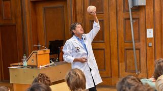 Prof. Dr. med. Achim Gass bei seinen Ausführungen mit einem Gehirn in der Hand.