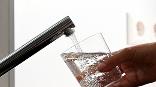 ILLUSTRATION - Eine Hand hält ein Wasserglas unter einen Wasserhahn. In Deutschland treten am Samstag strengere Regeln für Trinkwasser aus dem Hahn in Kraft. (zu dpa: «Strengere Regeln für Trinkwasser aus dem Wasserhahn treten in Kraft») +++ dpa-Bildfunk +++