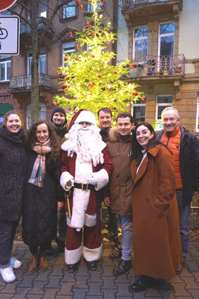 ADG-Vorsitzender Alex Lastovezki (3.v.r.) und seine Vorstandkollegen unter dem hell erleuchteten Weihnachtsbaum.