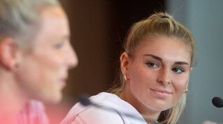 Jule Brand im Kreis der Nationalmannschaft bei einer Pressekonferenz zur EM 2022. Sie schaut in Richtung Svenja Huth.