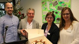 Pascal Hoffmann (v.l.) und Roland Träger überreichen eine Geburtstagstorte an die Seniorenberaterinnen Beate Preuss und Sarah Hofrichter.