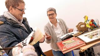 Benny Schindelhauer (l.) wird an der Kasse von Desi Fontanella bedient. Das Buch „Italiens Weinküche“ möchte er zu Weihnachten verschenken.