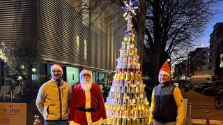 Alex Baum (v.l.), Uwe Franken als Nikolaus und Damian Dworatzek präsentieren ihren Pappbecher-Weihnachtsbaum.