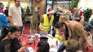 Große und kleine Künstler beim kreativen Malen und Basteln an einem Tisch.