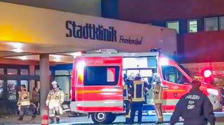 Feuerwehrleute stehen an einnem Rettungswagen vor der Stadtklinik Frankenthal. In dem Krankenhaus war am Montagabend ein Brand ausgebrochen. Beim Löschen fanden die Einsatzkräfte zwei Leichen.