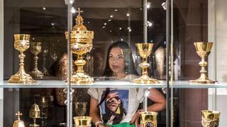 Eine Besucherin betrachtet hier die goldenen Trinkkelche aus dem Speyerer Domschatz in der Ausstellung „Kreuz und Krone“.
