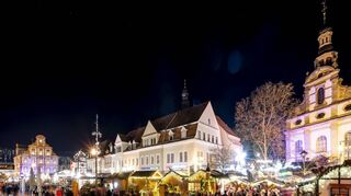 Luftiger ist besser: Dass die Stände beim Speyerer Weihnachts- und Neujahrsmarkt mehr Abstand zueinander haben und über die komplette Maximilianstraße verteilt sind als Verbindung zur Schlittschuhbahn am Altpörtel, kommt gut an. Zwischen Alter Münze (l.) und Dreifaltigkeitskirche (r.) ist täglich viel los.
