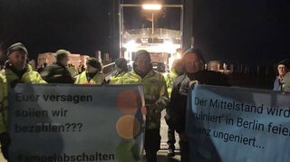 Landwirte stehen mit Plakaten am Fähranleger in Schüttsiel (Schleswig-Holstein).