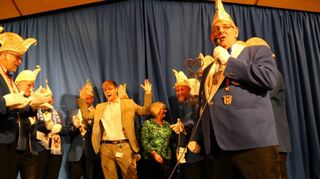 Erfolgreich umzingelt: Bürgerdienstleiter Silas Walz ergibt sich mit erhobenen Händen den Pilwe und händigt der Narrengilde den Schlüssel zum Neckarauer Rathaus aus.