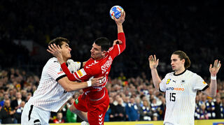 Deutschlands Julian Köster (l) verteidigt gegen Andy Schmid aus der Schweiz. Deutschlands Juri Knorr (r) schaut zu.