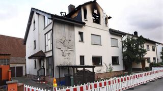 Das Haus in Ladenburg wurde nach dem tödlichen Brand abgesperrt. Vor dem Eingang haben Menschen Lichter zum Gedenken an die Opfer aufgestellt.