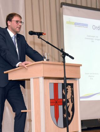 Bürgermeister Florian König erklärt den Bürgern in der Pestalozzihalle in Edingen auch die Finanzen.