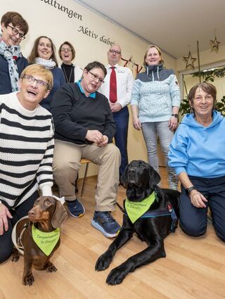 Die Hauptakteure tragen Halsband: Dackel „Smilla“ und Labrador „Caluma“ werden beim Verein Canis Lupus Therapeuticus in der Seniorenresidenz Storchenpark zu Therapiebegleithunden ausgebildet. Schirmherrin Bürgermeisterin Monika Kabs (h. l.) informiert sich bei Doris Verveur (v. l.), Ulla Spiering und Kerstin Markgraf, Julia Weiss( hinten, v. l.) Chantal Verveur, Michael Müller und Diana Bertram hören zu.
