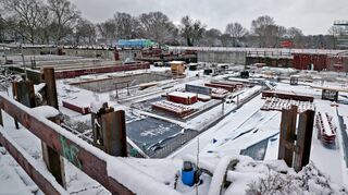 Rund 5000 Quadratmeter misst die Baugrube für das Kombibad im Herzogenried, es ist aktuell mit die größte in Mannheim. Rechts hinten steht der Sprungturm des benachbarten Freibads.