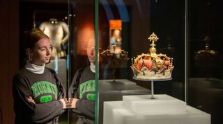 Eine Besucherin im Historischen Museum in Speyer betrachtet eine Krone aus der Zeit der Habsburger-Dynastie.