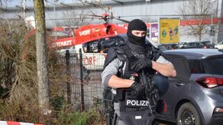 Ein schwerbewaffneter Polizist an der Schule in St. Leon-Rot. Zum Einsatz wurde neben 15 bis 20 Einsatzfahrzeugen auch ein Hubschrauber alarmiert.