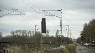 Setzrissschäden am Bahndamm bei Bürstadt sorgen für schief stehende Oberleitungsmasten.