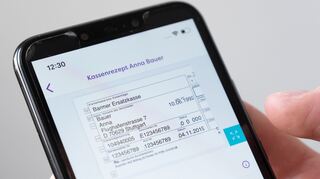 Auf einem Smartphone wird in einer App ein digitales Rezept einer fiktiven Patientin dargestellt (gestellte Szene).