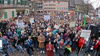Regenbogenfahnen und selbstgebastelte Pappschilder in der Menschenmenge auf dem Marktplatz sollen zeigen: Ladenburg bleibt bunt.