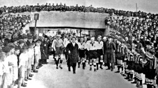 Die deutschen Spieler (allen voran Bundessportlehrer Otto Nerz) laufen durch das Marathontor ins Stadion, die Stelle, durch die heute die Waldhof-Fans auf die Otto-Siffling-Tribüne des Carl-Benz-Stadions gelangen.