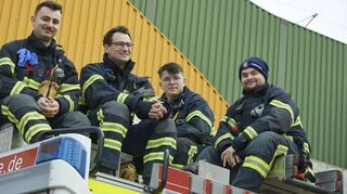 Feuerwehrleute blicken von ihrem Wagen hinunter: Einsatzkräfte sorgen für die Sicherheit der Besucher.