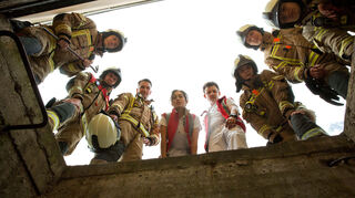 Ein Mann ist in den Kellerschacht gefallen. Feuerwehrmann Pio (Mark Zak, v.l.n.r), Markus (Max Hemmersdorfer) Nina (Sabrina Amali), Paul (Paul Zichner), Billy (Anna Schimigk) und weitere Feuerwehrmänner kommen am Einsatzort an.