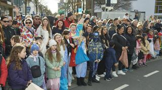 Bei schönem Wetter warten große und kleine Besucherinnen und Besucher auf den Beginn des Fastnachtsumzugs.
