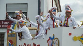 „Howwe helau!“ ruft der Elferrat des Hofheimer Carneval Vereins. Der weiße Wagen schlängelt sich durch die Straßen.