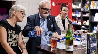 Wohl bekomm’s: Uwe Ittensohn stellt in der Buchhandlung Osiander sein neues Werk „Letzte Lese“ im Gespräch mit Bereichsleiterin Dagmar Strubl (l.) und Önologin Karoline Gaul (r.) vor und erläutert die Vier-Finger-Regel für Pfälzer Weinschorle.