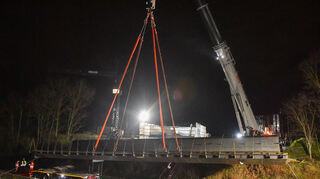 Das erste Teilstück der Brücke wird angehoben und in die richtige Position gebracht