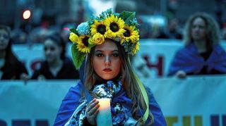 Eine ukrainische Frau hält eine Kerze während einer Demonstration anlässlich des zweiten Jahrestags der russischen Invasion.