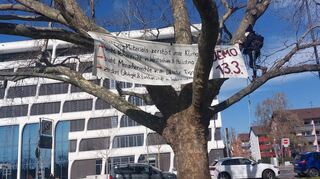 Eines der Protestbanner der Gruppierung „Letzte Generation“ hing am Samstag an einem Baum vor dem Firmengebäude von Heidelberg Materials.