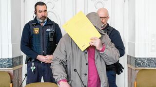 Auch am zweiten Prozesstag wird der Angeklagte Arthur K. von Justizbeamten zunächst in Handschellen, die er dann ablegen darf, in den Saal geführt.