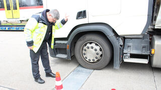 Hauptkommissar Uwe Welle weist einen Lkw-Fahrer auf der Waage ein.