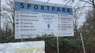Hinweisschild vor dem Sportpark, genau genommen sind es zwei: einer westlich im Pfeifferswörth, einer östlich am Neckarplatt. Beide sind durch die Riedbahn-Brücke getrennt.