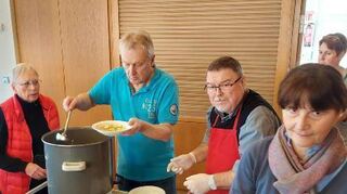 Roswitha (l.) und Manfred Falkenberg (2.v.r.) geben Suppe aus.