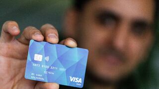 Ein Geflüchteter hält eine Debitcard in der Hand. Sie soll den Bargeldverkehr zwischen Verwaltungen und Asylbewerbern minimieren.
