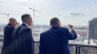 Oberbürgermeister Christian Specht (r.) zeigt dem US-Generalkonsul Norman Thatcher Scharpf (Mitte) auf dem E-Hochhaus, wie sich das ehemalige US-Militärgelände auf Franklin gewandelt hat.