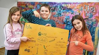 Auf dem Plakat ist noch viel Platz: Laura (l.), Timo und Isabell zeigen, was die Ferienspielkinder glücklich macht.