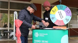 Lothar Uhlmann (l.) lässt sich vom „Digitalen Engel“ Johannes Dillmann die Funktionsweise seines Tablets und der externen Tastatur erklären.