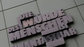Das berühmte Zitat „Die Würde des Menschen ist unantastbar“, Artikel 1 des Grundgesetzes, prangt an der Fassade eines Gerichts.