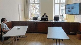 Der Klima-Aktivist Raúl Semmler sitzt mit Richter Christoph Streiß im Mannheimer Amtsgericht. Der Anwalt des FC Bayern ist online zugeschaltet.