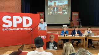 Spitzenkandidat Reinhold Götz bei seiner Rede auf der Schönau. Auf der Leinwand hinter ihm sind die ersten Vier auf der Liste eingeblendet.